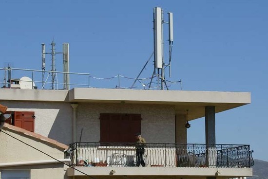 Un homme marche sur le balcon de son appartement, le 12 avril 2003 dans le quartier Saint-Jérôme, à Marseille, au-dessus duquel est installée une antenne-relais de téléphonie mobile.