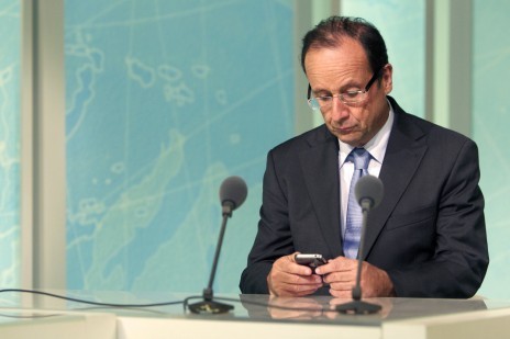 François Hollande regarde son smartphone dans les studios de Martinique première, le 4 juillet 2011 (Patrick Coppée/AFP)