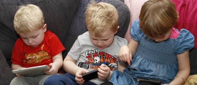 Des enfants de 3, 6 et 5 ans utilisant smartphones et tablettes (illustration). © ANGOT/SIPA